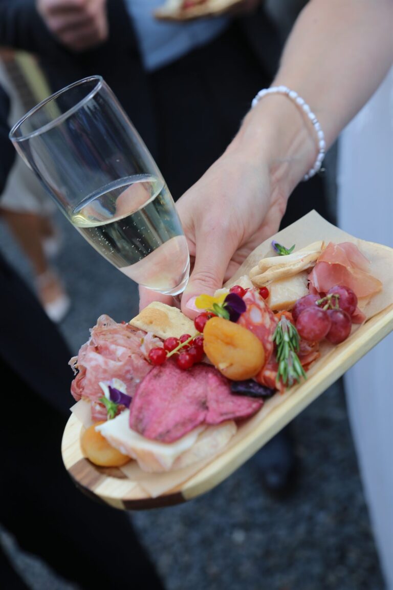 Borrelplankje met salumi, kaas en eetbare bloemen, met een glas prosecco