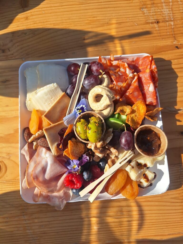 Borrelplateau van bovenaf met Italiaanse kazen, salumi, olijven, noten en vijgen
