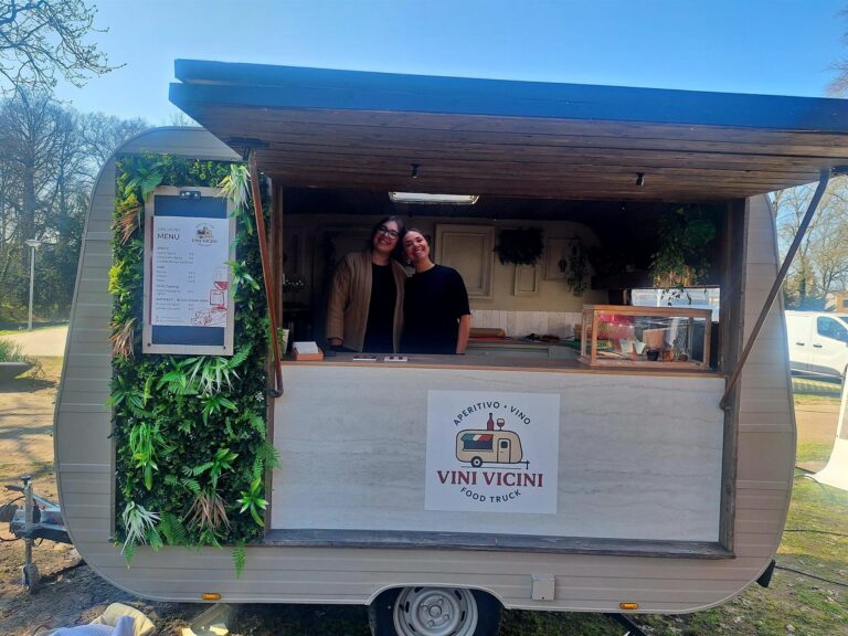 Twee gastvrouwen in de geopende caravan tijdens een evenement