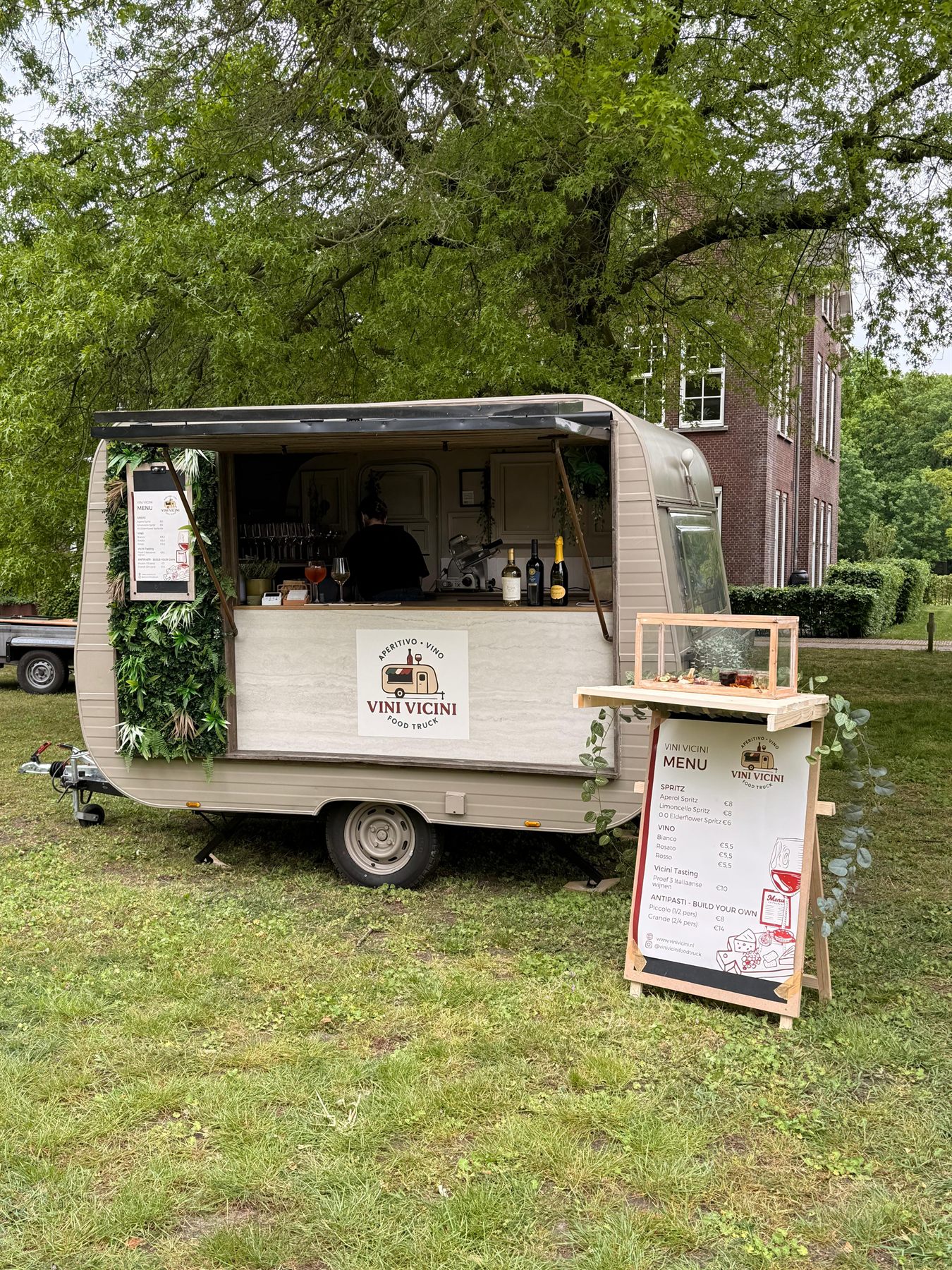 De Vini Vicini caravan op een landgoed onder oude bomen