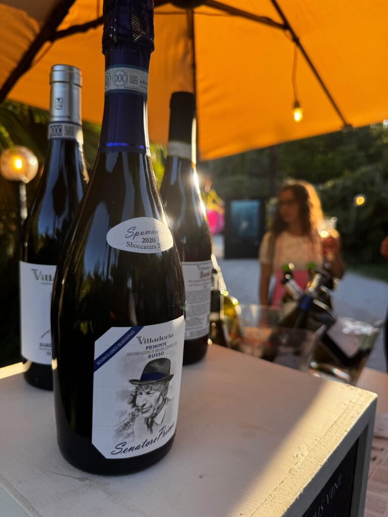 Italiaanse wijnflessen onder een oranje parasol in de avondzon