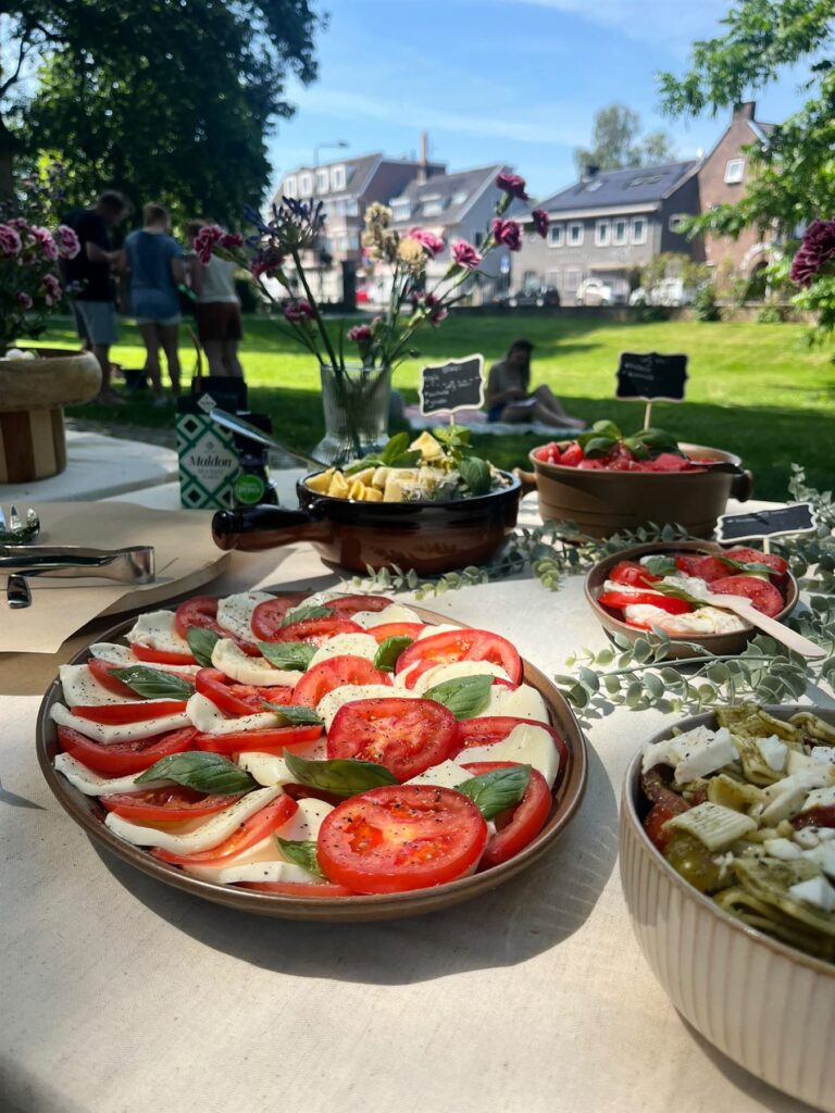 Buffet met caprese, bruschetta en pastasalade tijdens een tuinfeest